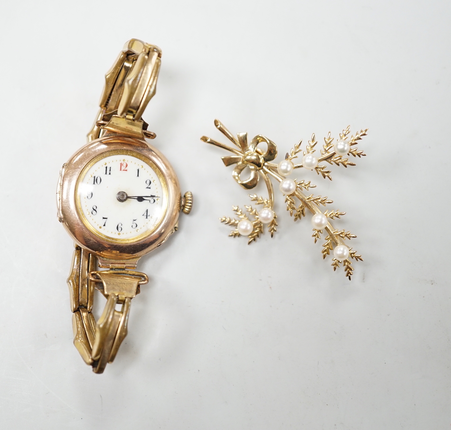 A lady's early 20th century 9ct gold, manual wind wrist watch, on a gold plated strap, together with a modern 9ct gold and seed pearl floral spray brooch.